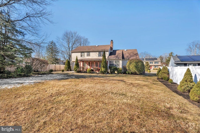 rear view of property with a lawn