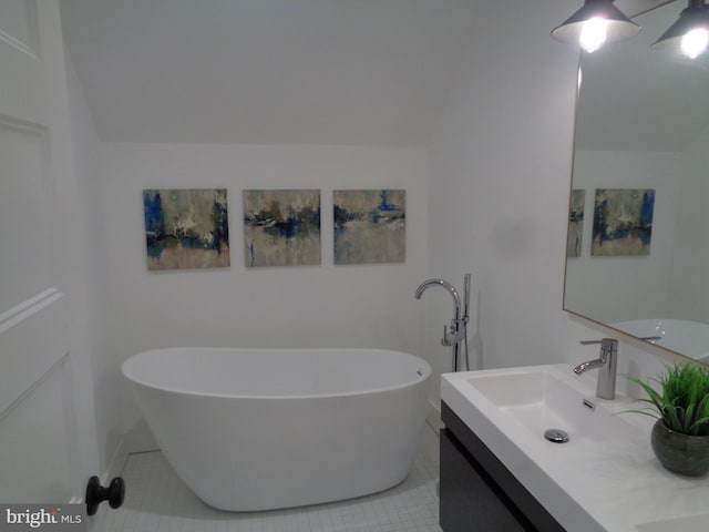 bathroom with a washtub, vanity, tile patterned floors, and lofted ceiling