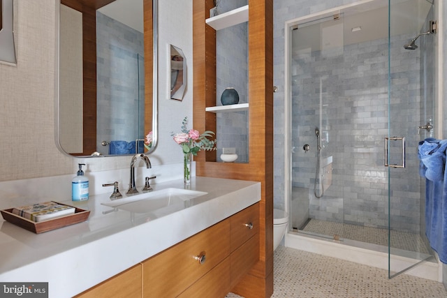 bathroom featuring vanity, a shower with door, and toilet