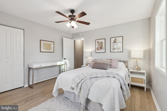 bedroom featuring visible vents, baseboards, ceiling fan, wood finished floors, and a closet