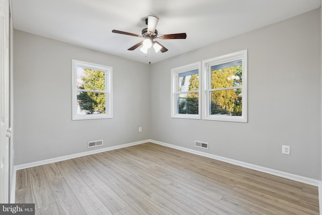 unfurnished room featuring visible vents, light wood-style flooring, and baseboards