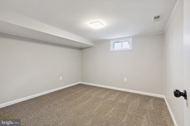 below grade area featuring carpet, visible vents, and baseboards