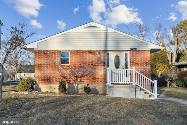 view of front of property with a front yard and brick siding