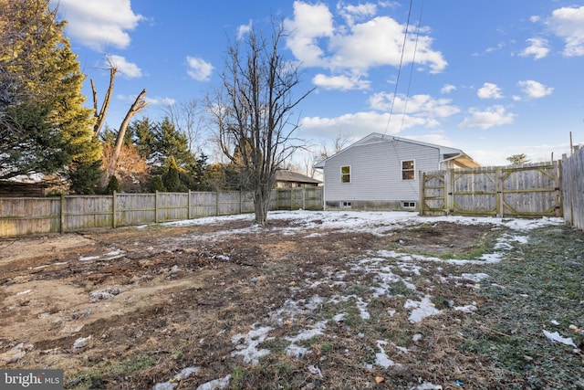 yard covered in snow with a fenced backyard