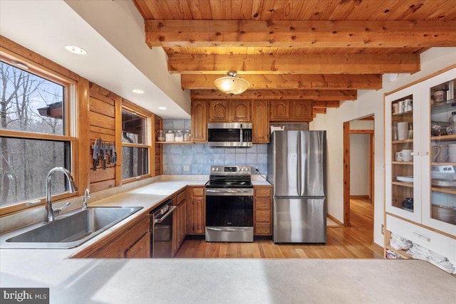 kitchen featuring appliances with stainless steel finishes, tasteful backsplash, sink, wood ceiling, and beam ceiling