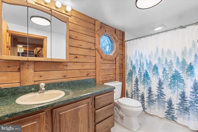 bathroom with vanity, a shower with shower curtain, toilet, and wood walls