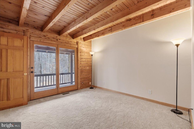 interior space with beamed ceiling, wood walls, carpet flooring, and wooden ceiling