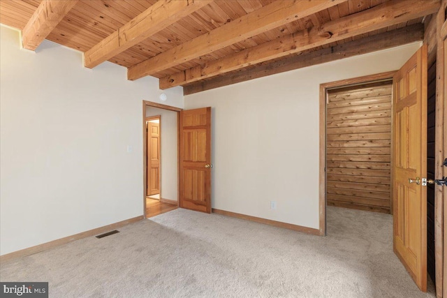 unfurnished room with beam ceiling, wood ceiling, and light carpet