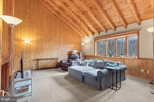 living room with beam ceiling, high vaulted ceiling, carpet, and wood walls