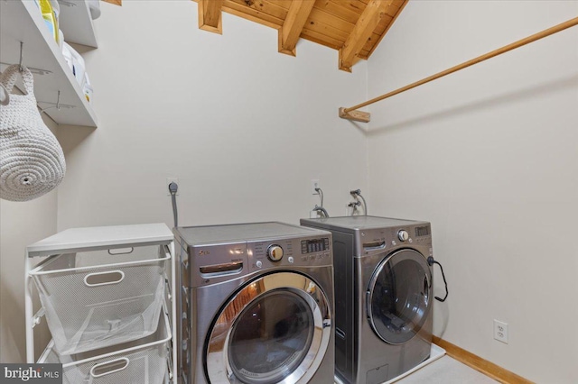 laundry area with wood ceiling and washing machine and clothes dryer