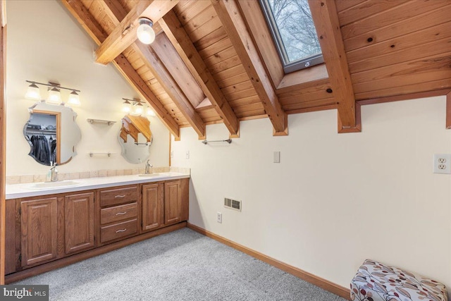 bathroom featuring vanity, vaulted ceiling with skylight, and wooden ceiling