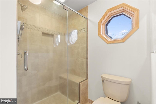 bathroom with toilet and an enclosed shower