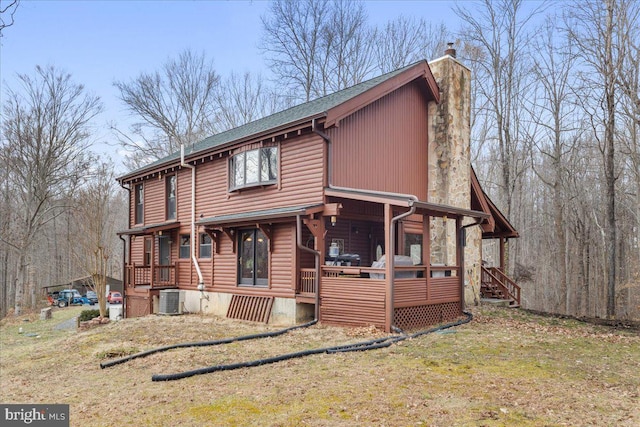 view of front of home featuring central AC unit, a front lawn, and a porch