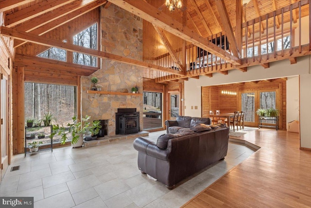 living room with light wood-type flooring, wooden ceiling, lofted ceiling with beams, and a wood stove