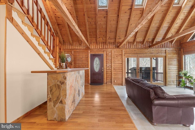 unfurnished living room with wooden walls, light hardwood / wood-style flooring, and wooden ceiling