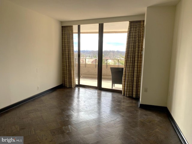 empty room featuring floor to ceiling windows and dark parquet flooring