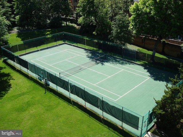 view of tennis court featuring a yard