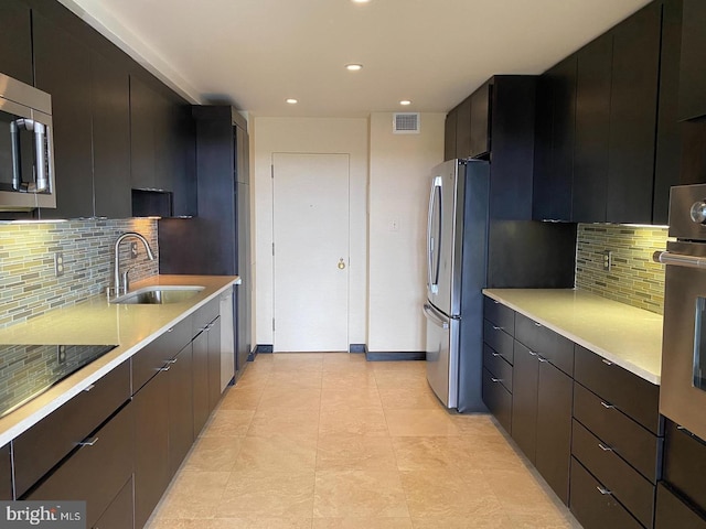 kitchen featuring stainless steel appliances, sink, and backsplash