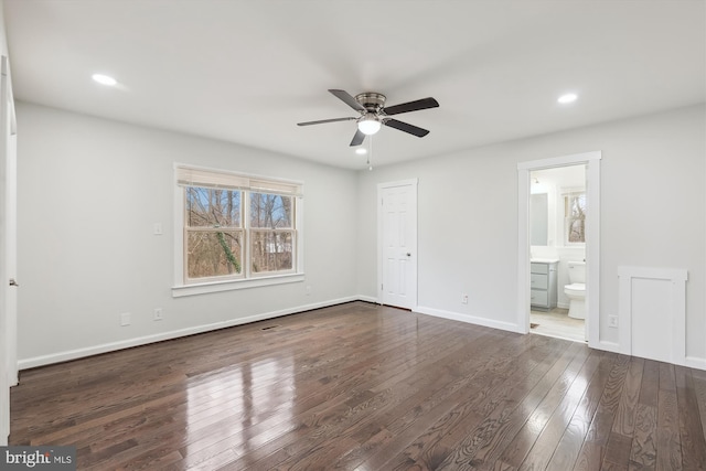 unfurnished bedroom featuring ceiling fan, ensuite bath, and dark hardwood / wood-style flooring