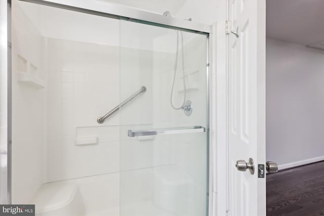 bathroom featuring hardwood / wood-style flooring and a shower with shower door