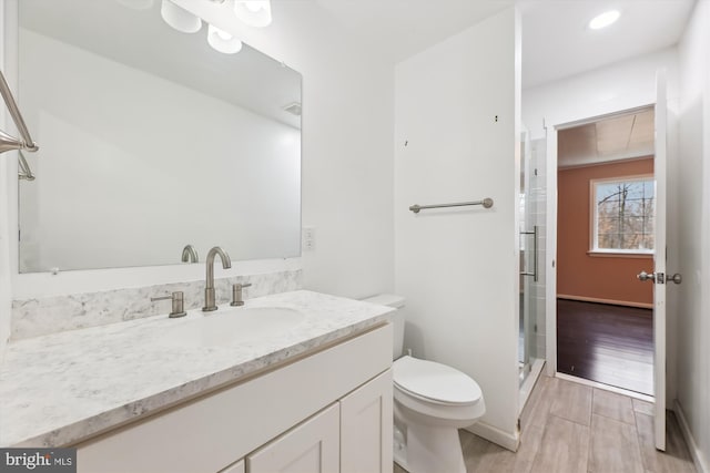 bathroom with vanity, an enclosed shower, hardwood / wood-style flooring, and toilet