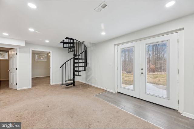 interior space featuring french doors, plenty of natural light, and light carpet