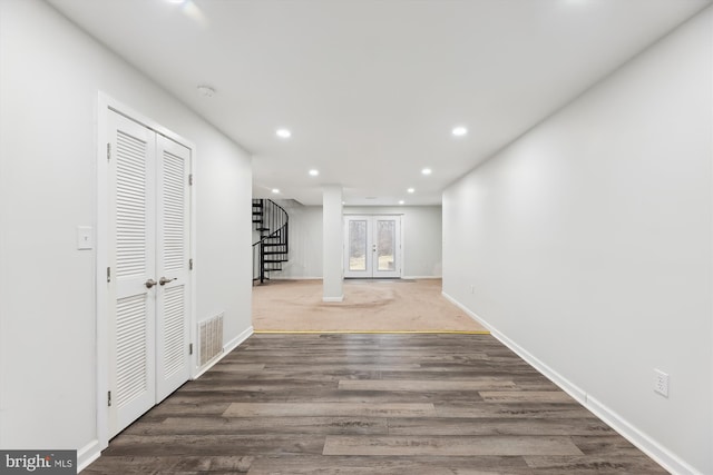 hall with dark wood-type flooring and french doors