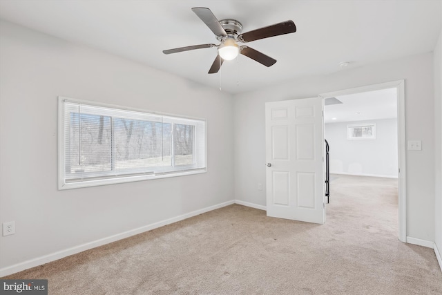 unfurnished room featuring light carpet and ceiling fan