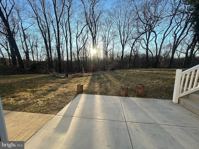 yard at dusk featuring a patio area