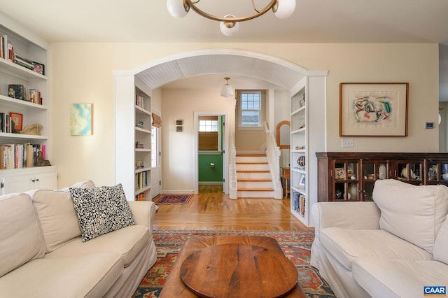 living room with built in shelves and light wood-type flooring