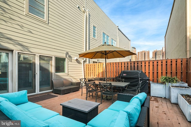 wooden terrace with an outdoor hangout area and grilling area