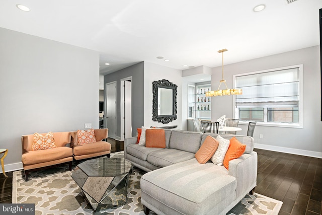 living room featuring dark wood-type flooring and a notable chandelier