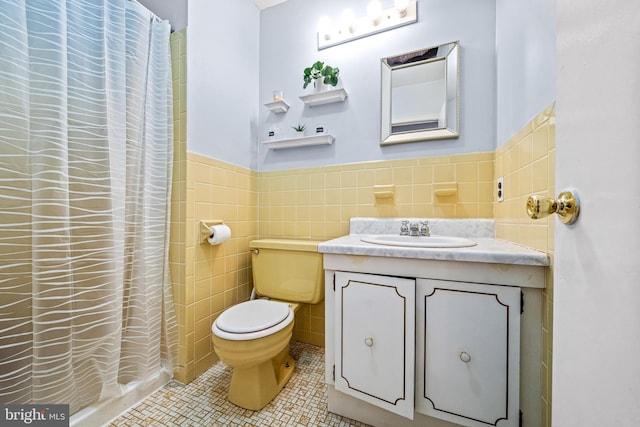 bathroom with tile walls, vanity, toilet, tile patterned floors, and a shower with shower curtain