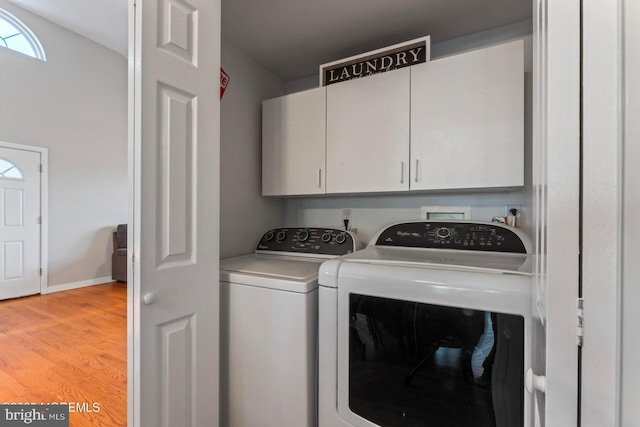 laundry room with independent washer and dryer, light hardwood / wood-style flooring, and cabinets