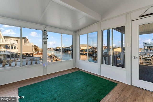 unfurnished sunroom with lofted ceiling, a wealth of natural light, and a water view