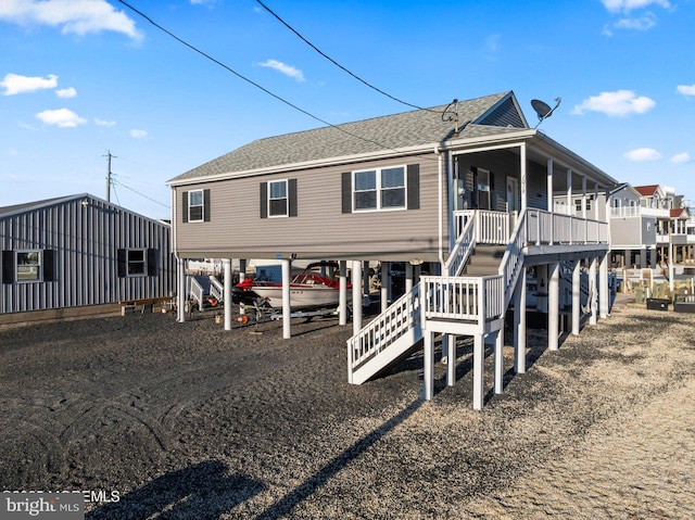 rear view of property featuring covered porch