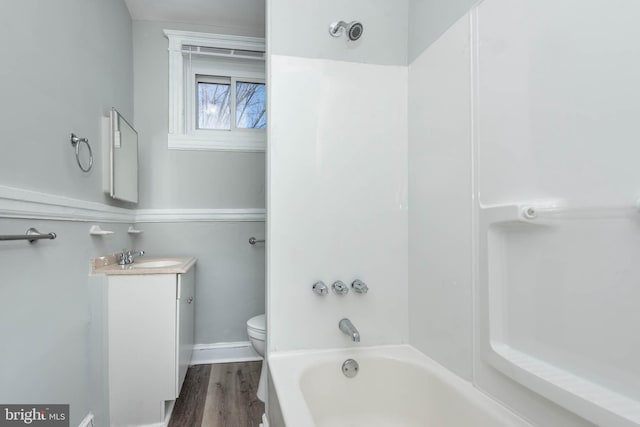 full bathroom with bathtub / shower combination, vanity, toilet, and hardwood / wood-style floors