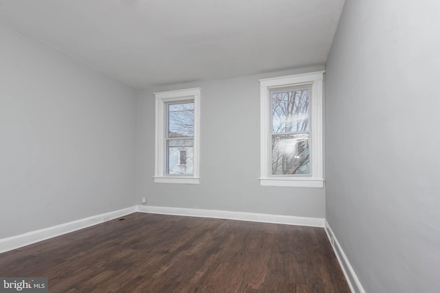 unfurnished room with dark wood-type flooring