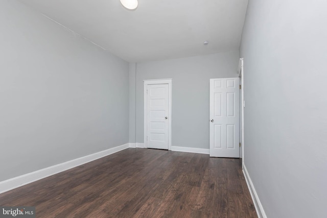 spare room with dark wood-type flooring