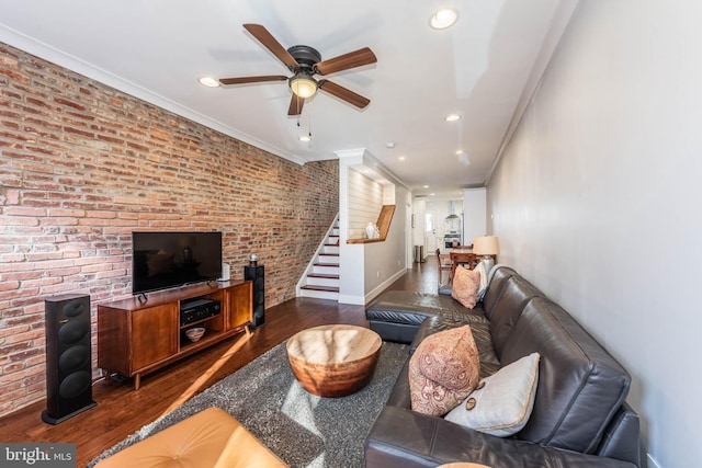 living room featuring ceiling fan, ornamental molding, brick wall, and dark hardwood / wood-style floors