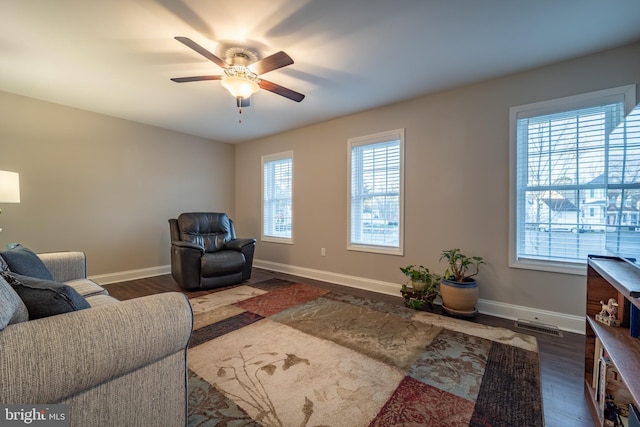 living room with ceiling fan and dark hardwood / wood-style flooring