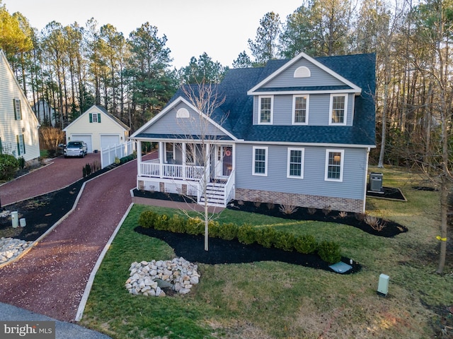 view of front of property with a porch, a front yard, central AC unit, a garage, and an outbuilding