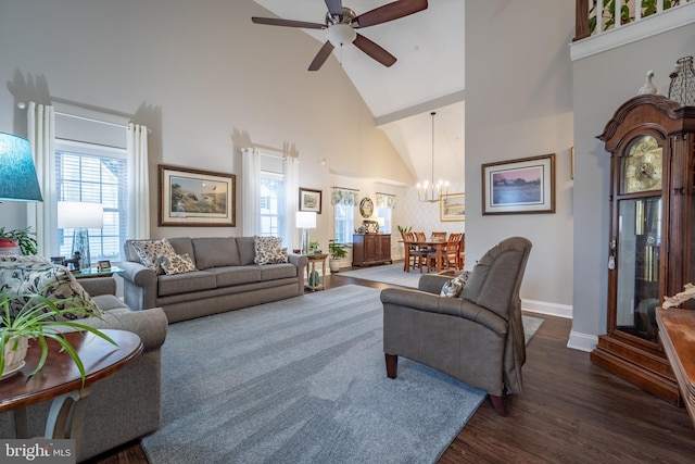 living room featuring ceiling fan with notable chandelier, dark wood-type flooring, and high vaulted ceiling