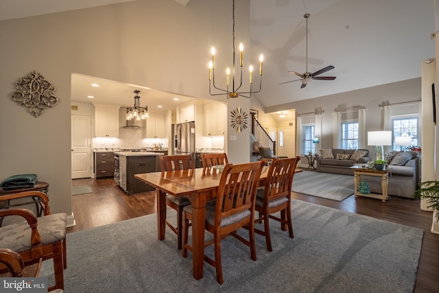 dining room with dark wood-type flooring, a notable chandelier, and high vaulted ceiling