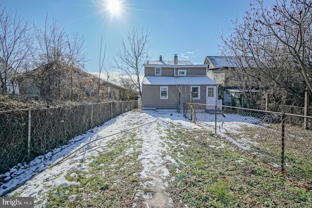 view of snow covered back of property