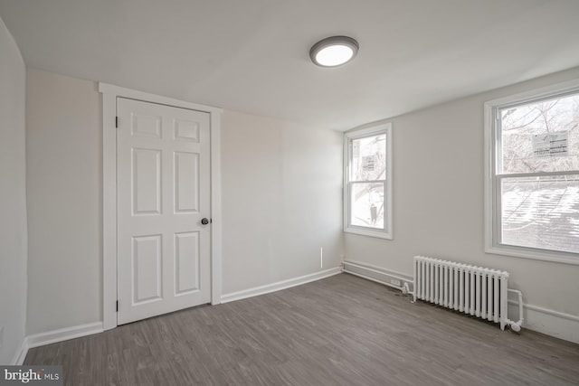 bonus room featuring hardwood / wood-style flooring, plenty of natural light, and radiator