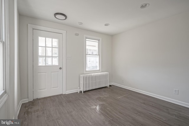 doorway to outside featuring dark hardwood / wood-style flooring and radiator heating unit