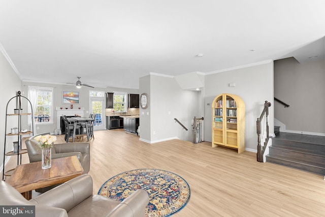 living room with ceiling fan, ornamental molding, and light hardwood / wood-style floors