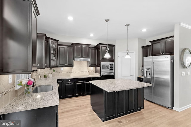 kitchen featuring a kitchen island, sink, stainless steel appliances, and light hardwood / wood-style floors