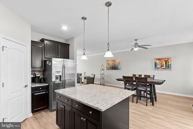 kitchen with light hardwood / wood-style flooring, stainless steel refrigerator with ice dispenser, a kitchen island, decorative light fixtures, and ceiling fan